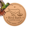 A copper disk bird bath with a silhouette of a bird on it, featuring 2mm thick reinforced copper and designed for garden wate