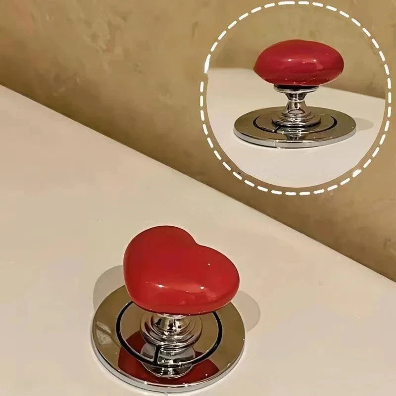 Bouton de chasse d'eau en forme de cœur rouge avec une base chromée.