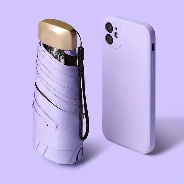 A white compact folding UV protection umbrella is shown next to a light-colored smartphone.
