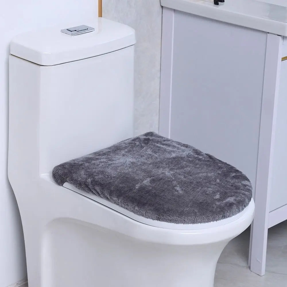 A white toilet with a gray protective seat cover placed on the seat.