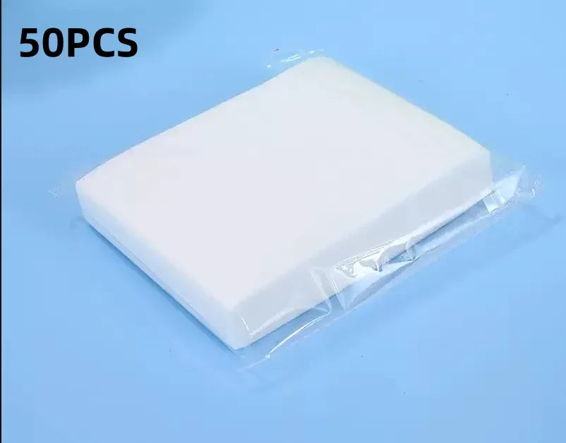 Comprimé de lessive blanc emballé dans un emballage plastique transparent, montré sur un fond bleu clair.
