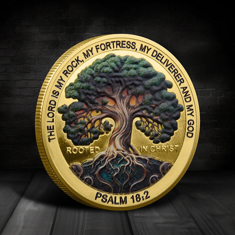 A gold coin featuring a silhouette of a tree with roots, surrounded by scripture text.