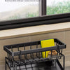 Black kitchen sponge holder and drain rack with a hanging hook placed inside a kitchen sink.
