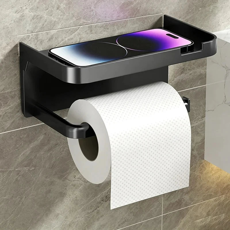 A black no-drill toilet paper holder with a storage shelf mounted on a wall, holding a roll of white paper.