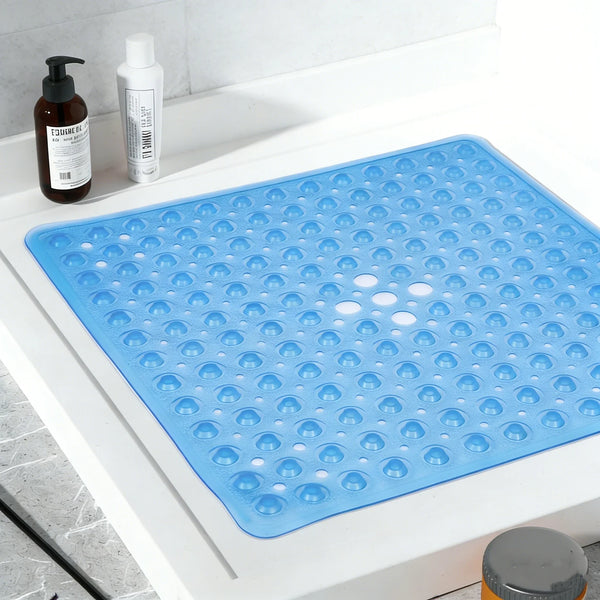 A blue non-slip shower mat with suction cups is displayed on a white surface next to bottles.