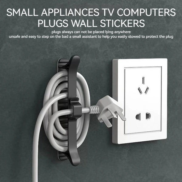 A white cable organizer with an adhesive mount is shown next to a wall electrical outlet.