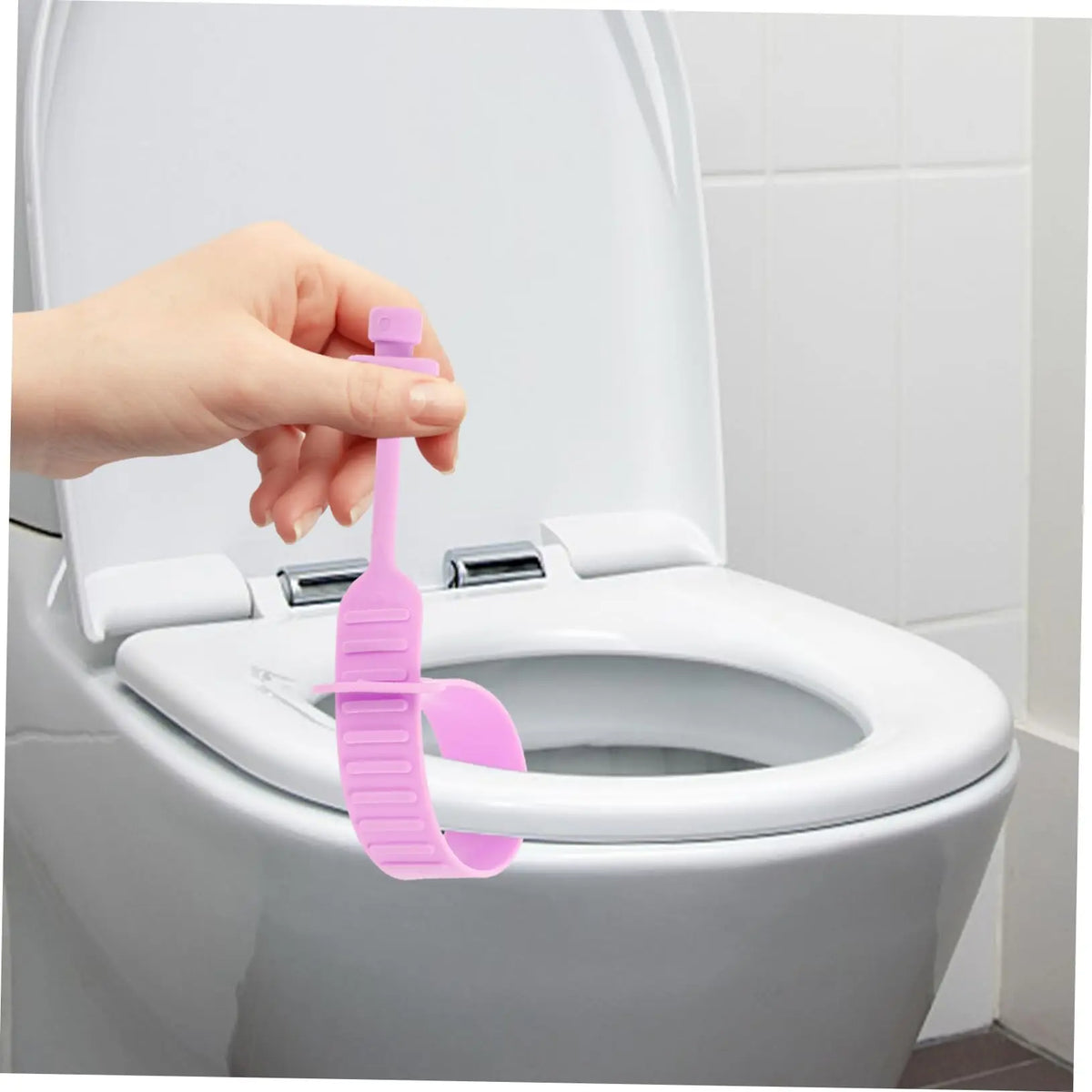 A hand is lifting a silicone toilet lid lifter from the inside of a white toilet bowl.