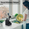 A woman is using a black kitchen helper soap dispenser with a sponge holder and brush on a kitchen counter.