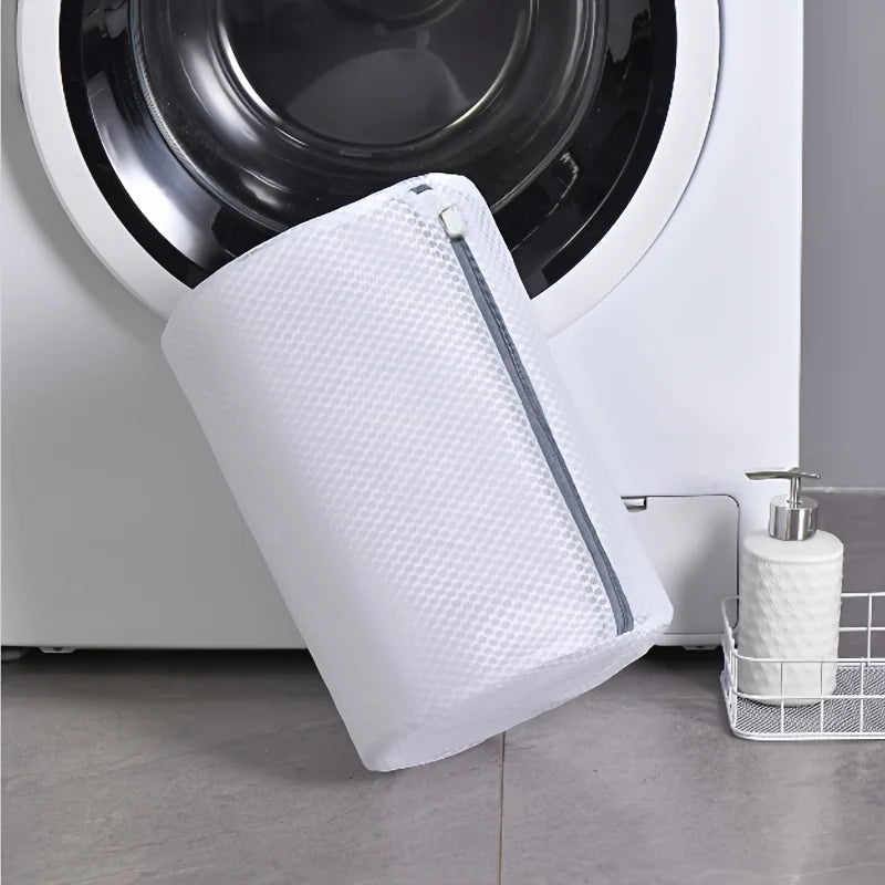 A white mesh shoe cleaning bag is shown next to a washing machine drum.