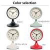 A selection of five round alarm clocks in black, turquoise, milky white, and red colors.