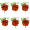 Trois boutonnières vintage en soie orange avec des fleurs blanches et du feuillage vert.