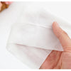 A hand is holding a white portable mini hand wipe for hygiene.