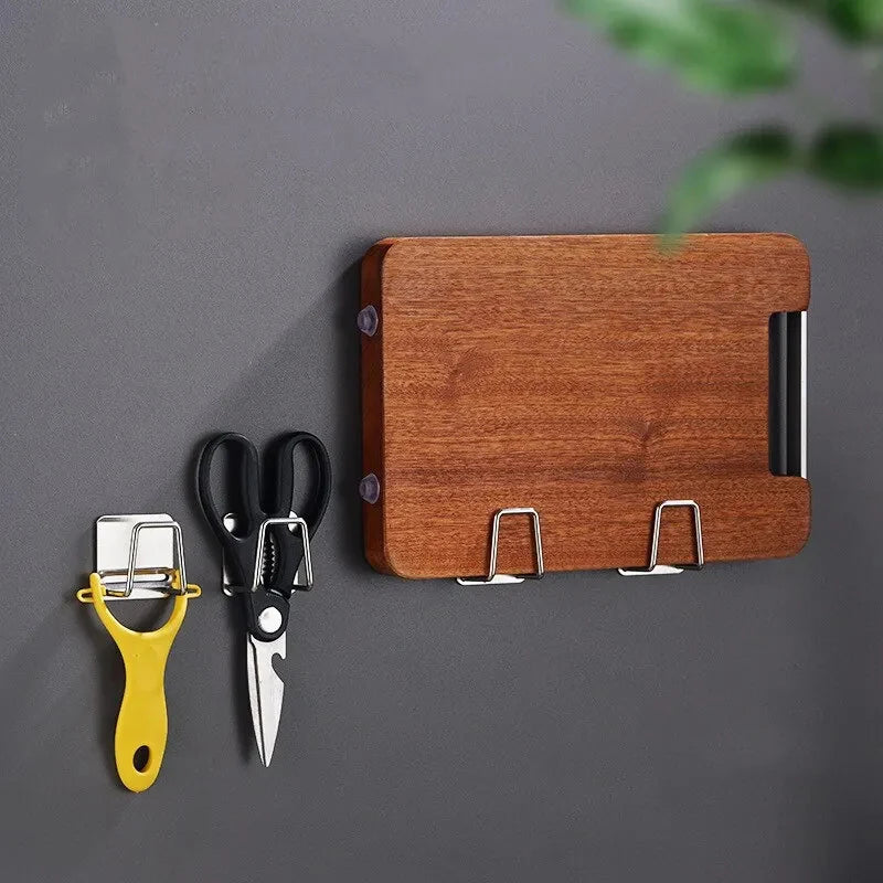 A wooden sponge holder rack with a stainless steel knife and a yellow suction cup tool displayed on a gray surface.