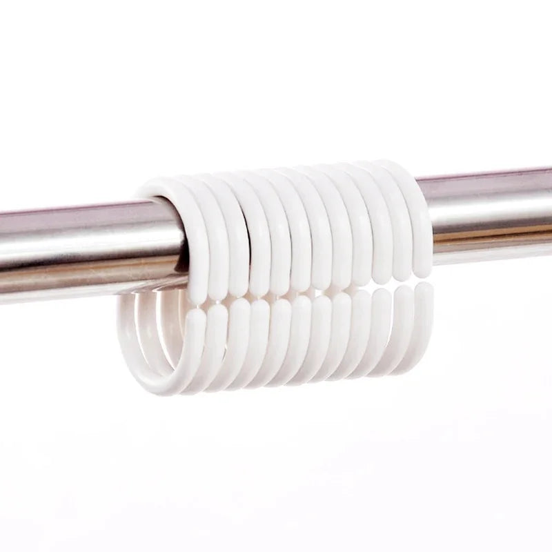 White silicone shower curtain rings coiled on a metal rod.