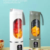 Extractor de jugo eléctrico portátil blanco con gran capacidad junto a frutas frescas.