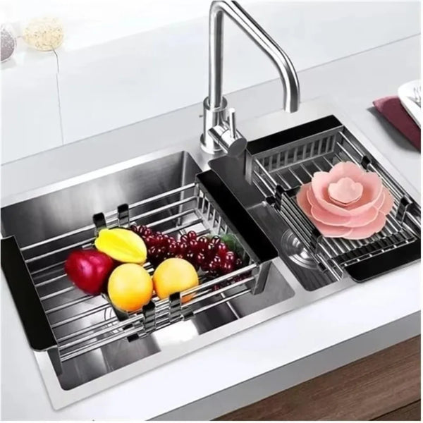 A stainless steel sink drain basket with a rose-colored flower placed inside, shown on a kitchen counter.
