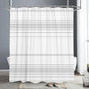 White abstract geometric line shower curtain hanging from a metal rod