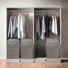 A closet organizer displaying hanging clothes and storage boxes for quilts in a modern wardrobe.