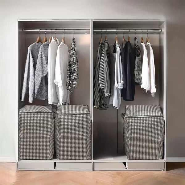 A closet organizer displaying hanging clothes and storage boxes for quilts in a modern wardrobe.