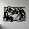 Black silhouette wall art depicting a group of figures gathered around a table with a central cross.
