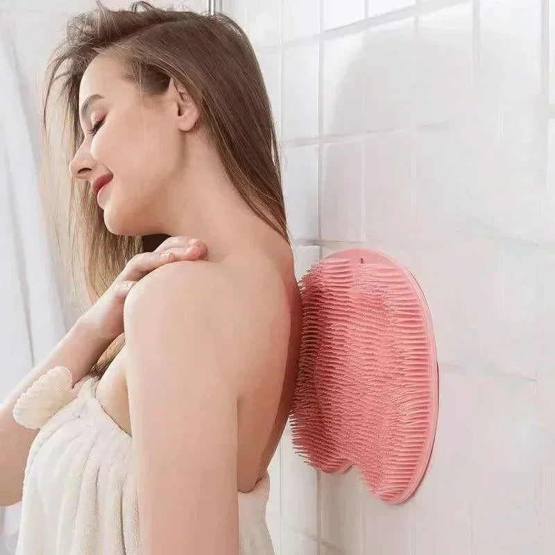 Una mujer está usando una estera de masaje para los pies de silicona rosa en una pared de azulejos blancos.