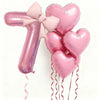 Un juego de seis globos de látex en forma de corazón rosa, incluyendo el número uno, atados con cinta rosa.