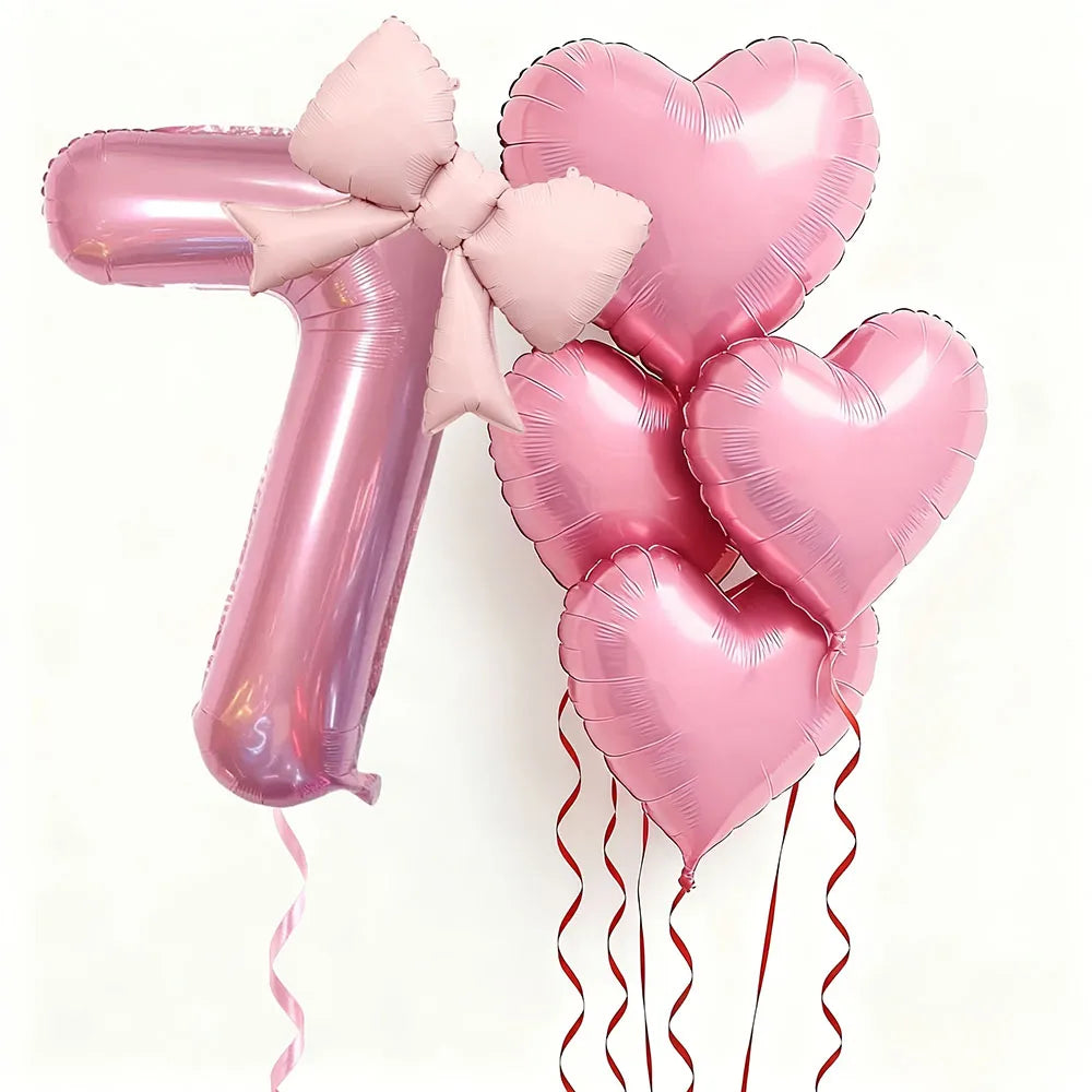 Un juego de seis globos de látex en forma de corazón rosa, incluyendo el número uno, atados con cinta rosa.