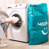Un sac de lavage et de rangement en nylon résistant à l'usure à côté d'une machine à laver blanche.