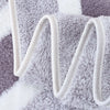 A close-up of a fluffy gray and white microfiber bath towel set with white straps.