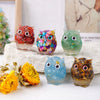 Colección de adornos de goteo de búho hechos de piedra natural triturada en varios colores y texturas.