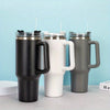 Three insulated stainless steel tumblers with handles and straws in black, white, and gray colors.