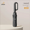 A black automatic folding umbrella is shown standing upright on a light surface.