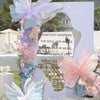 A floral and butterfly decoration display featuring pink, purple, and blue butterflies and flowers against a white backdrop.