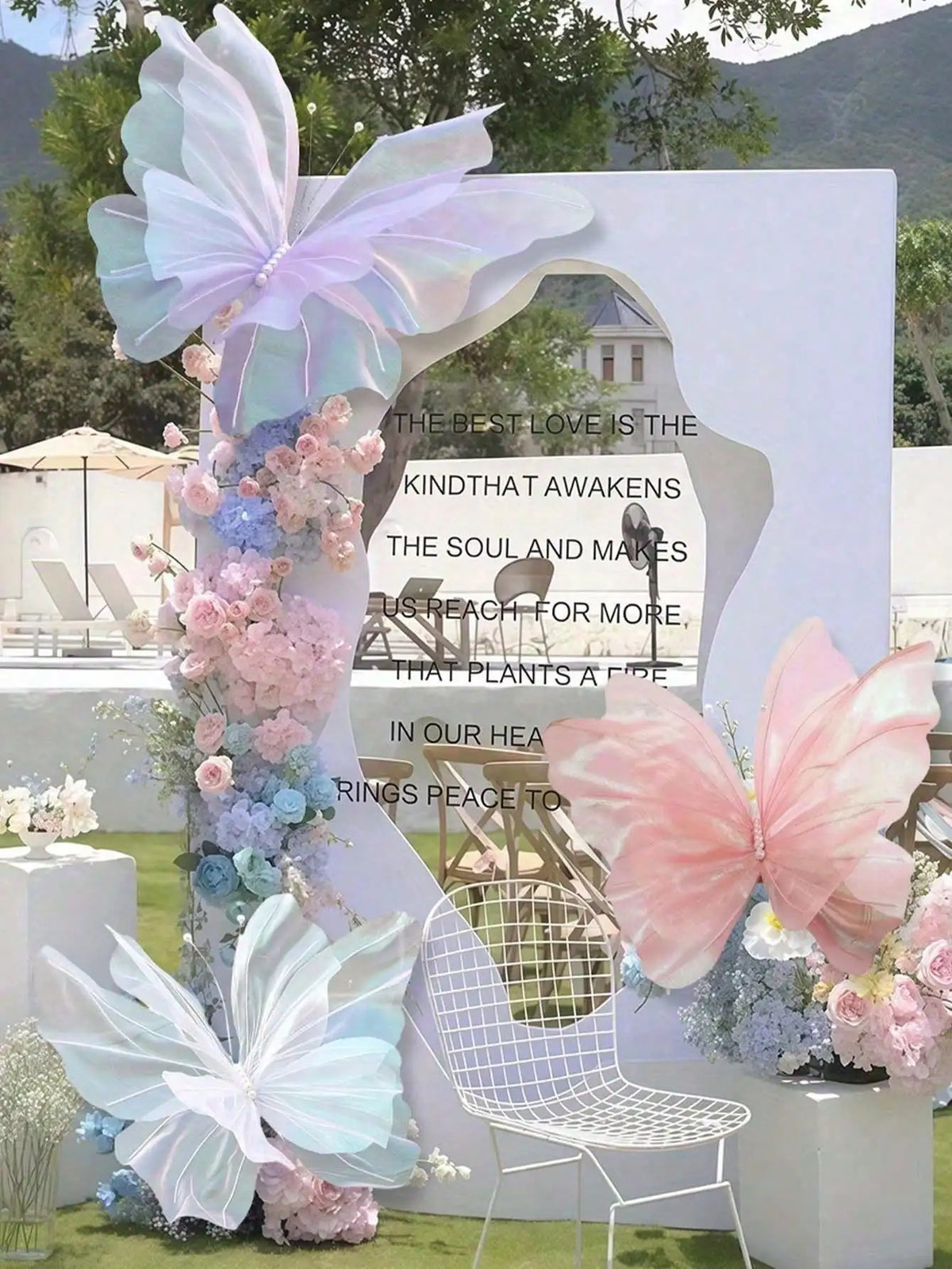 A floral and butterfly decoration display featuring pink, purple, and blue butterflies and flowers against a white backdrop.