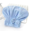 A light blue microfiber hair drying cap and towel with a fluffy texture, resting on a wire rack.