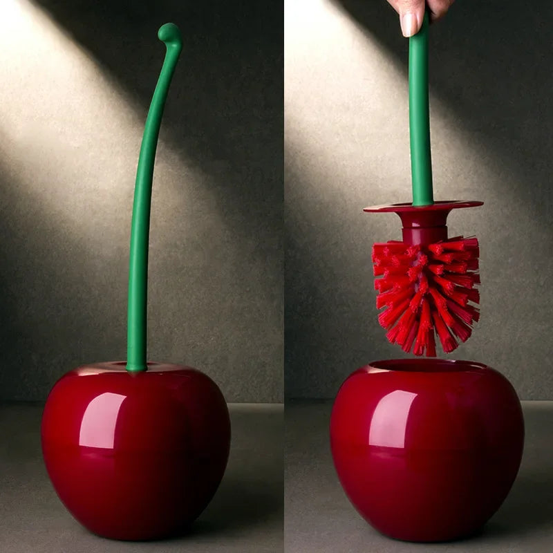 A green decorative cherry-shaped toilet brush set with a red handle and bristles against a neutral background.