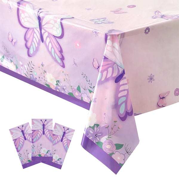 A pink watercolor butterfly tablecloth draped on a table, with folded fabric samples nearby.