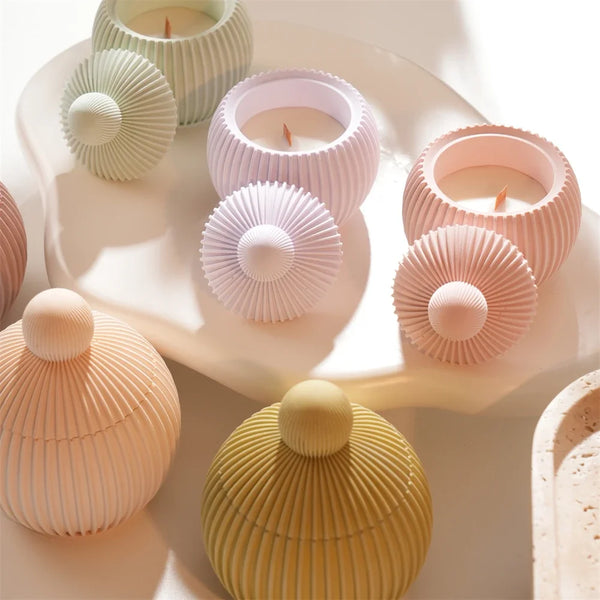 A collection of round silicone candle molds in various pastel shades, including pink, green, and yellow, arranged on a white 