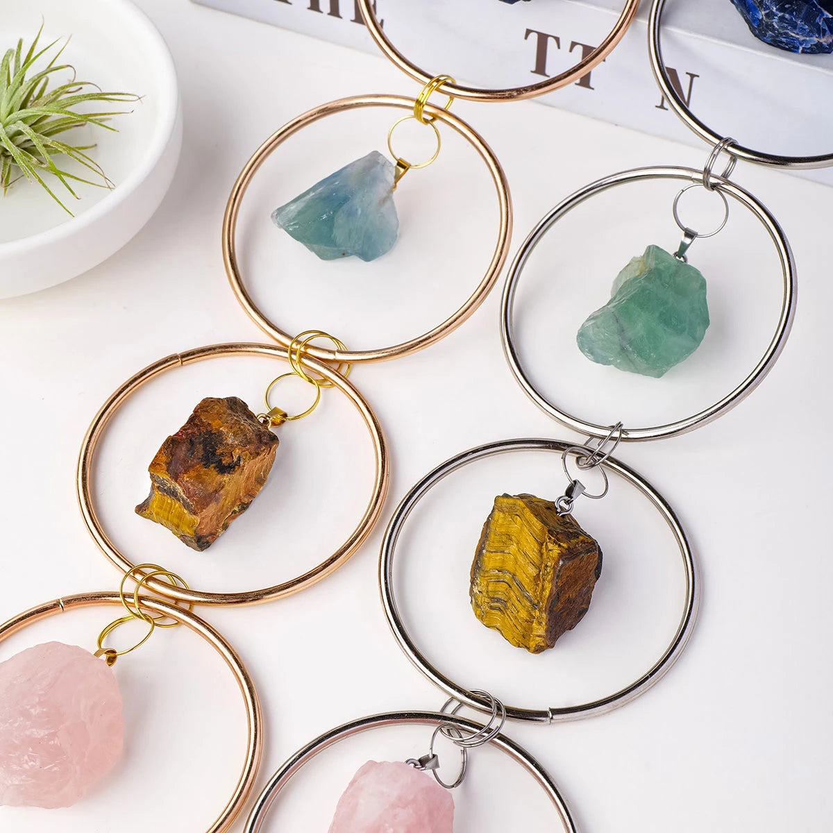 Gold-toned circular crystal healing ornaments featuring various natural stones like turquoise, amber, and rose quartz.