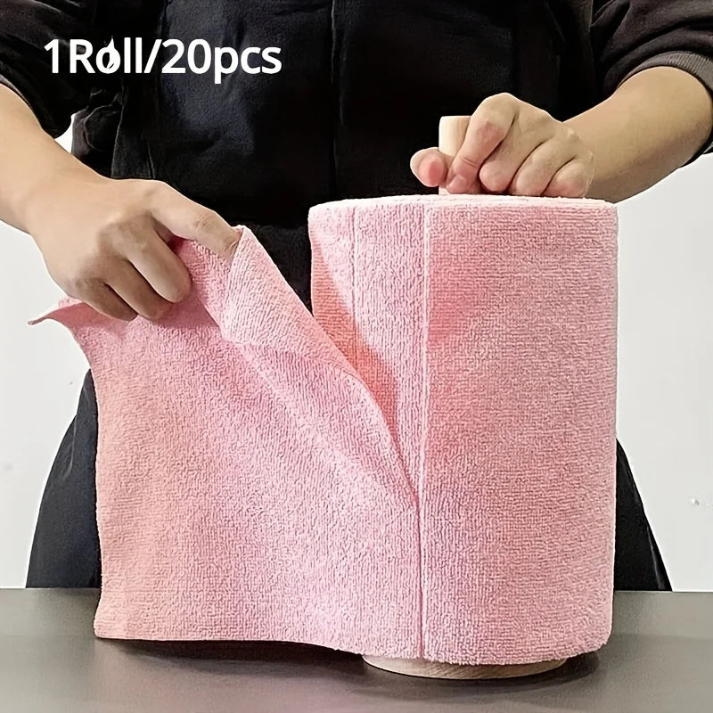 A hand is holding a roll of pink reusable microfiber cleaning cloths, showing the texture and size.