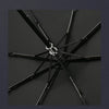 A black folding katana sword umbrella with a silver hilt is shown in a dark, overhead view.