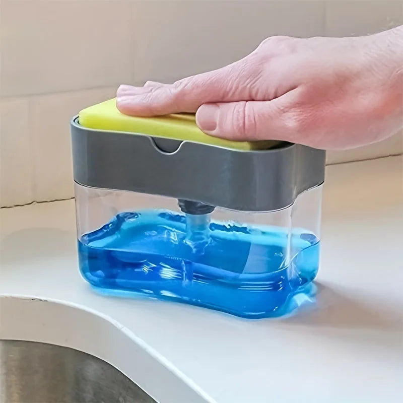 A hand is pressing a yellow plunger on a clear container filled with blue liquid soap.
