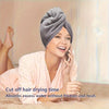 A woman is using a microfiber hair drying wrap towel while talking on a phone.