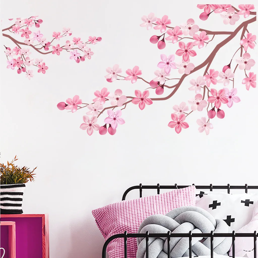 Pink peach tree branches with blossoms decorating a white wall