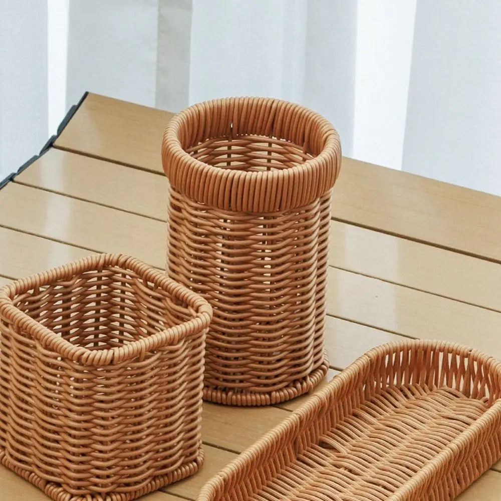 A collection of handwoven rattan serving baskets in natural tan color on a wooden surface.