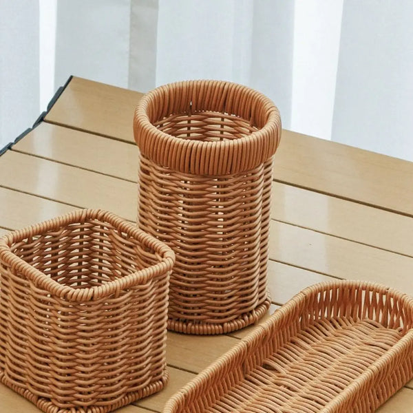 A collection of handwoven rattan serving baskets in natural tan color on a wooden surface.