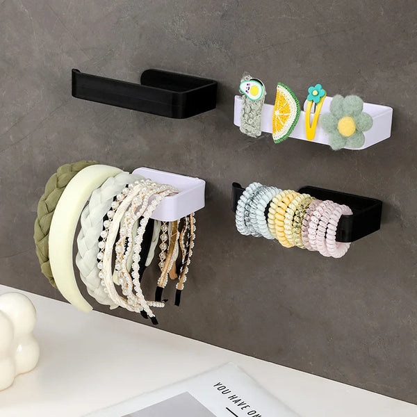 A display of various beaded and natural fiber hair accessories mounted on a gray wall.
