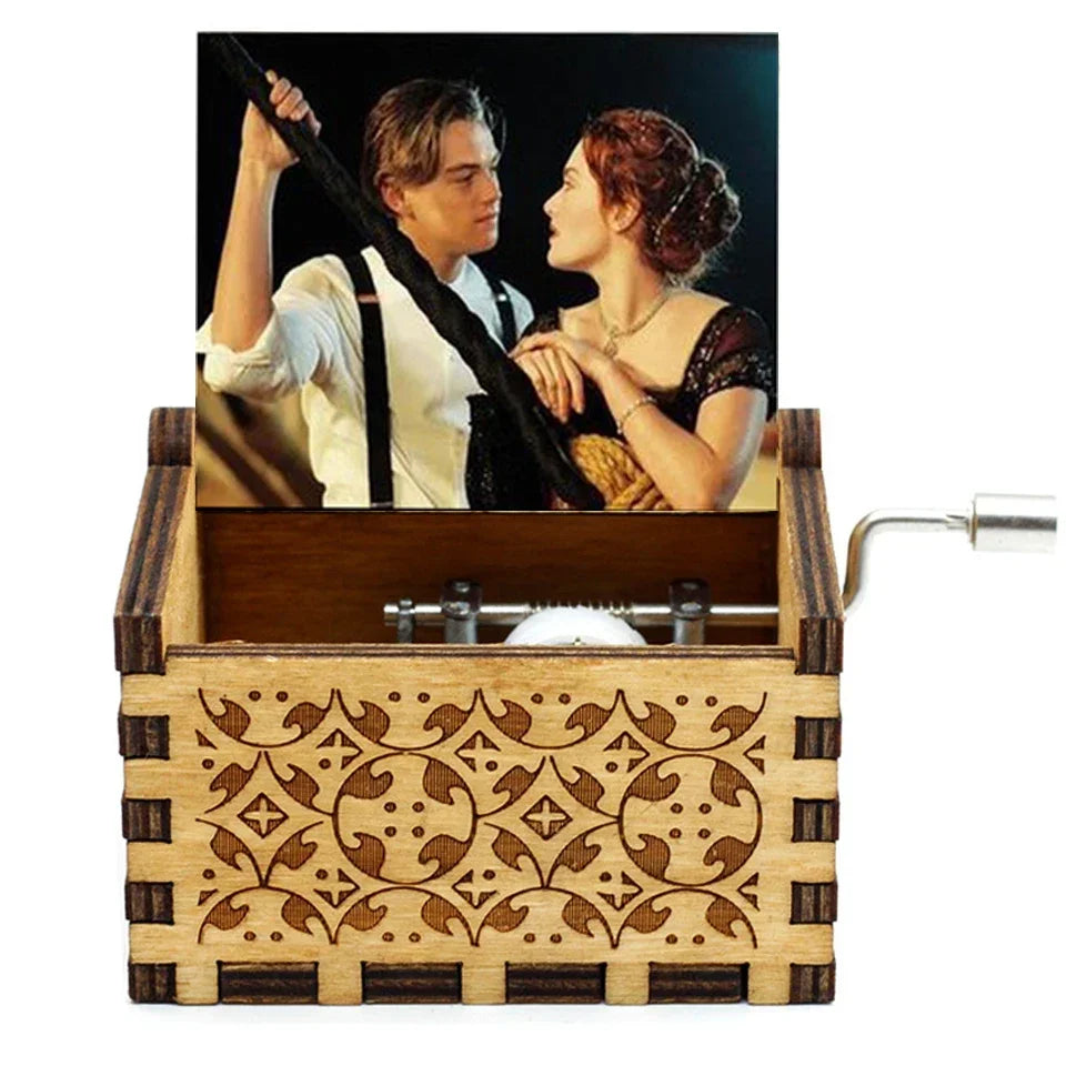Antique wooden hand crank music box featuring a portrait of a man and woman.