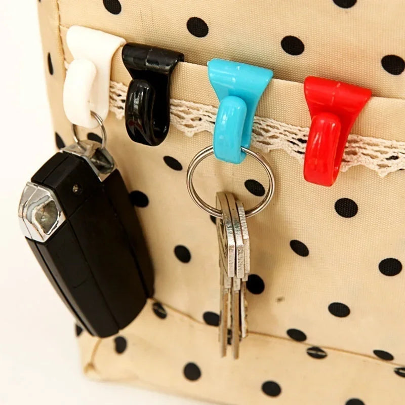 A set of four colorful key holder clips attached to a light beige polka-dot fabric bag.