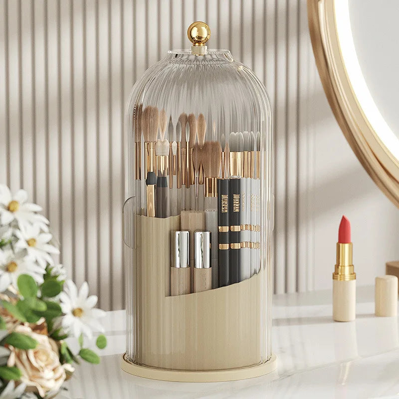 A clear glass organizer with a lid holds various makeup brushes and tools for rotating use.